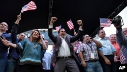 Gubernur Puerto Rico, Ricardo Rosello merayakan hasil referendum bersama dengan anggota Kongres AS Jennifer Gonzalez (kiri) di markas besar partai Progresif Baru, San Juan, Puerto Rico, 11 Juni 2017. (AP Photo/Carlos Giusti). 