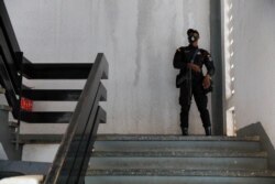 FILE - A police officer stands guard before the bail hearing of 21 people who were detained by police and accused of unlawful assembly and promoting an LGBTQ agenda, in Ho, Volta region, Ghana, June 4, 2021.