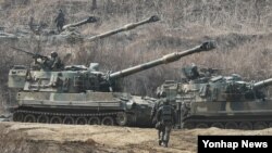 지난해 3월 한국 파주시의 접경지역에서 미-한연합훈련 '키 리졸브' 연습이 진행 중인 가운데, 한국군 K-55 A1 자주포가 GPS 교란작전을 대비해 방열 훈련을 하고 있다.