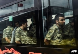Detained Turkish soldiers who allegedly took part in a military coup arrive in a bus at the courthouse in Istanbul on July 20, 2016, following the military coup attempt of July 15.