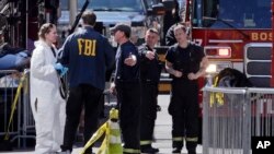 Agen-agen FBI berbicara dengan petugas pemadam kebakaran di Boston serta fotografer tempat kejadian perkara di lokasi pemboman Marathon Boston. (AP/Charles Krupa)