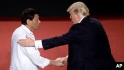 Presiden Filipina Rodrigo Duterte berjabat tangan dengan Presiden AS Donald Trump di sela KTT ASEAN di Manila, 13 November 2017.