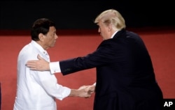 Philippines President Rodrigo Duterte, left, shakes hands with U.S. President Donald Trump during an ASEAN Summit, in Manila, Philippines, Nov. 13, 2017.
