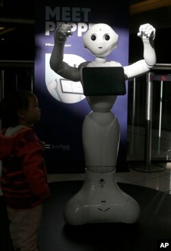 Kids are fascinated by 4-foot-tall Pepper, who can chirp, dance and pose for selfies, Dec. 22, 2016.