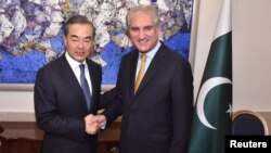Pakistan's Foreign Minister Shah Mehmood Qureshi shakes hands with Chinese State Councilor and Foreign Minister Wang Yi at the Ministry of Foreign Affairs in Islamabad, Pakistan, Sept. 8, 2018. (Ministry of Foreign Affairs handout via Reuters).