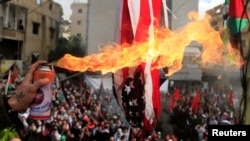 Protesters set a U.S flag on fire near the U.S. Embassy in Awkar north of Beirut, Lebanon, Dec. 10,2017.