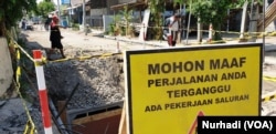 Warga melintas di lokasi proyek yang terhenti karena menjadi obyek OTT KPK. (Foto:VOA/Nurhadi)