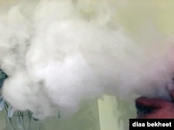 FILE- A man vapes with an electronic cigarette, exhales in Fair Oaks, Virginia. (Photo: Diaa Bekheet).