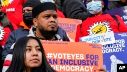 Activists rally on the steps of New York's City Hall ahead of a vote to allow lawful permanent residents to cast votes in elections to pick the mayor, City Council members and other municipal officeholders, Dec. 9, 2021, in New York. 