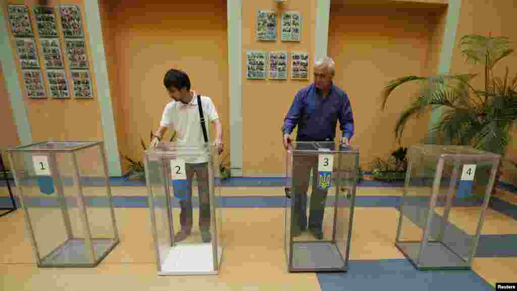 Election commission officials install ballot boxes at a poling station in Kyiv, May 24, 2014. 