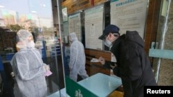 중국 후베이성 우한의 약국에서 남성이 마스크를 구매하고 있다. 