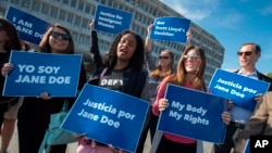 FILE - Activists with Planned Parenthood demonstrate in support of a pregnant 17-year-old being held in a Texas facility for unaccompanied immigrant children to obtain an abortion, Oct. 20, 2017. A federal court in Washington told the Trump administration Friday the government can't interfere with the ability of pregnant immigrant teens being held in federal custody to obtain abortions.