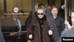 Hillary Clinton meninggalkan Rumah Sakit Presbyterian New York didampingi putrinya Chelsea, dan suaminya – mantan presiden Bill Clinton (tidak tampak), Rabu (2/1). 