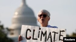 រូបឯកសារ៖ សកម្មជនបរិស្ថានម្នាក់បានកាន់បដាចូលរួមបាតុកម្មមួយដើម្បីដាក់សម្ពាធលើអ្នកតាក់តែងគោលនយោបាយឲ្យយកចិត្តទុកដាក់លើការប្រែប្រួលអាកាសធាតុ នៅរដ្ឋធានីវ៉ាស៊ីនតោន កាលពីថ្ងៃទី២៣ ខែកញ្ញា ឆ្នាំ២០១៩។ 