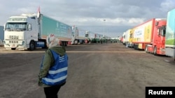 FILE PHOTO: Trucks carrying humanitarian aid from Egyptian NGOs for Palestinians, wait for the reopening of the Rafah crossing at the Egyptian side