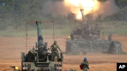 FILE - Taiwan's military fire artillery from self-propelled Howitzers during the annual Han Kuang exercises in Hsinchu, northeastern Taiwan, Sept. 10, 2015. 