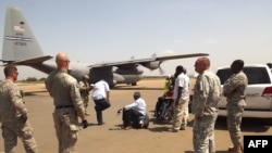 US army soldiers stand guard as a US army aircraft remains on the runway awaiting the arrival of American nationals who are being evacuated due to recent unrest and violence in South Sudan, on December 21, 2013, in Juba.