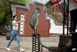 Tourists prepare to take photos in a retails area with a Taiwan theme showing a map of Taiwan in Beijing, China, April 13, 2016.