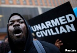 A man protests recent fatal shootings of two black teenagers, at a march in Clayton, Missouri, Oct. 10, 2014.