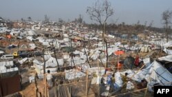 FILE - Rohingya refugees build a temporary shelter days after a fire burnt their home at a refugee camp in Ukhia, in the southeastern Cox's Bazar district on March 25, 2021.