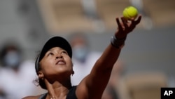 Japan's Naomi Osaka serves the ball to Romania's Patricia Maria Tig during Osaka's first-round victory at the French open tennis tournament at the Roland Garros stadium on May 30, 2021, in Paris. 