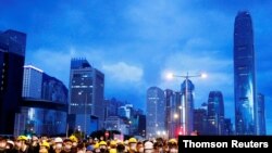  Anti-extradition bill protesters stand behind a barricade during a demonstration near a flag-raising ceremony for the anniversary of Hong Kong handover to China in Hong Kong, July 1, 2019.