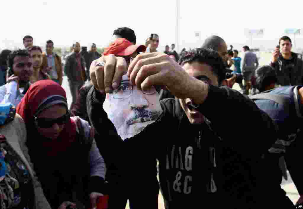 A man holds a part of a torn poster showing Egypt's ousted President Mohamed Morsi during clashes in Cairo, Jan. 8, 2014.