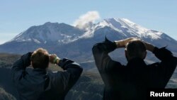 FILE - Visitors to the Coldwater Ridge Center look up at Mount St. Helens venting steam, Oct. 11, 2004. 