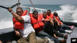 Cuban migrants picked up earlier on Puerto Rico's remote Mona Island sit on the deck of a U.S. Border Patrol boat. Now they are being sent to a processing center on mainland Puerto Rico where they could seek asylum.