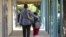 FILE - In this 2012 photo, a father walks his son, who is autistic, to the Nestle Avenue Elementary School in Los Angeles.