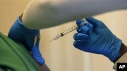 Registered nurse Charlene Luxcin administers a flu shot to a patient at the Whittier Street Health Center in Boston, Massachusetts, January 9, 2013. Boston declared a public health emergency Wednesday. 