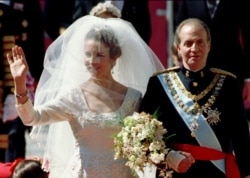 FILE - Spain's Princess Elena waves to the crowds as she is escorted by her father King Juan Carlos to the altar of Seville's cathedral on March 18, 1995.