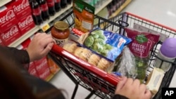 FILE - A shopper pushes a cart of groceries at a supermarket in Bellflower, Calif., on Feb. 13, 2023. 
