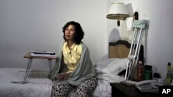 FILE - Ni Yulan sits on the bed in a hotel in Beijing, June 30, 2010. 