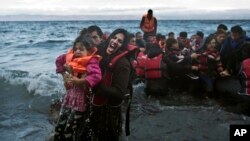 Seorang perempuan berteriak minta tolong saat dia dan anaknya tercebur ke laut, setibanya di pulau Lesbos, Yunani (2/10). 