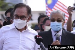 Mantan Perdana Menteri Malaysia Mahathir Mohamad (kanan) dan anggota parlemen oposisi Anwar Ibrahim (kiri) berbicara kepada media saat mereka memprotes penutupan parlemen di Kuala Lumpur pada 2 Agustus 2021. (Foto: AFP/Arif Kartono)