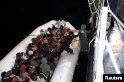 Migrants in a dinghy are rescued by Libyan members of the coast guard in the Mediterranean Sea off the coast of Libya, March 15, 2018.