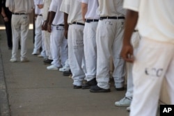 FILE – Prisoners line up for lunch at Elmore Correctional Facility in Alabama, June 18, 2015. U.S. sentencing guidelines have been eased for low-level, nonviolent drug offenses, shortening their terms and helping reduce U.S. incarceration rates.