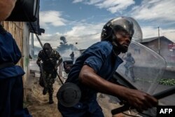 FILE - Burundi's policemen and army forces run after protesters against incumbent president Pierre Nkurunziza's bid for a 3rd term on 13 May 2015 in Bujumbura, May 13, 2015.