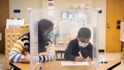 Pre-kindergarten teacher Sarah McCarthy works with a student at Dawes Elementary in Chicago, Monday, Jan. 11, 2021.