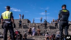 Polisi Spanyol mengawasi para migran yang baru tiba di pantai Pulau Canary, Spanyo, dengan perahu kayu, 23 November 2020. 