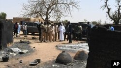 Mali's President Ibrahim Boubacar Keita inspects the damage after an attack by gunmen on Fulani herders in Ogossagou, Mali, March 25, 2019.