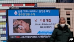 A huge screen about precautions against the COVID-19 is seen in downtown Seoul, South Korea, Feb. 23, 2020.