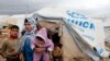 Syrian refugees leave their tents after heavy rain, Al-Zaatari refugee camp, Mafraq, Jordan, Jan. 8, 2013.
