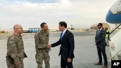 U.S. Defense Secretary Mark Esper, center, is greeted by U.S. military personnel upon arriving in Kabul, Afghanistan, Sunday, Oct. 20, 2019.