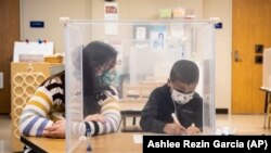 Seorang guru Sarah McCarthy bekerja dengan seorang siswa di Chicago, Senin, 11 Januari 2021. (Foto: AP)