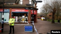 A police officer stands at a cordon around the bench where former Russian intelligence agent Sergei Skripal and his daughter Yulia were found after they were poisoned, in Salisbury, Britain, March 11, 2018. 