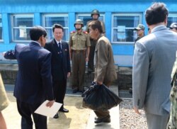 FILE - An unidentified North Korean fisherman, center, crosses the borderline at Panmunjom in Paju, South Korea, July 14, 2015. South Korea said Tuesday that it had sent back two North Korean fishermen who were rescued earlier this month from South Korean waters.
