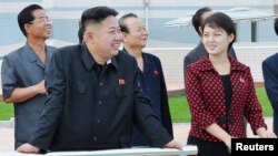 Pemimpin Korea Utara Kim Jong-Un (dua dari kiri) bersama istrinya, Komrad Ri Sol Ju, mengunjungi taman hiburan baru di Pyongyang (25/7).
