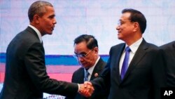 바락 오바마 미국 대통령(왼쪽)과 리커창 중국 총리가 지난해 11월 말레이시아 쿠알라룸푸르에서 열린 아세안 정상회의에서 악수하고 있다. (자료사진)